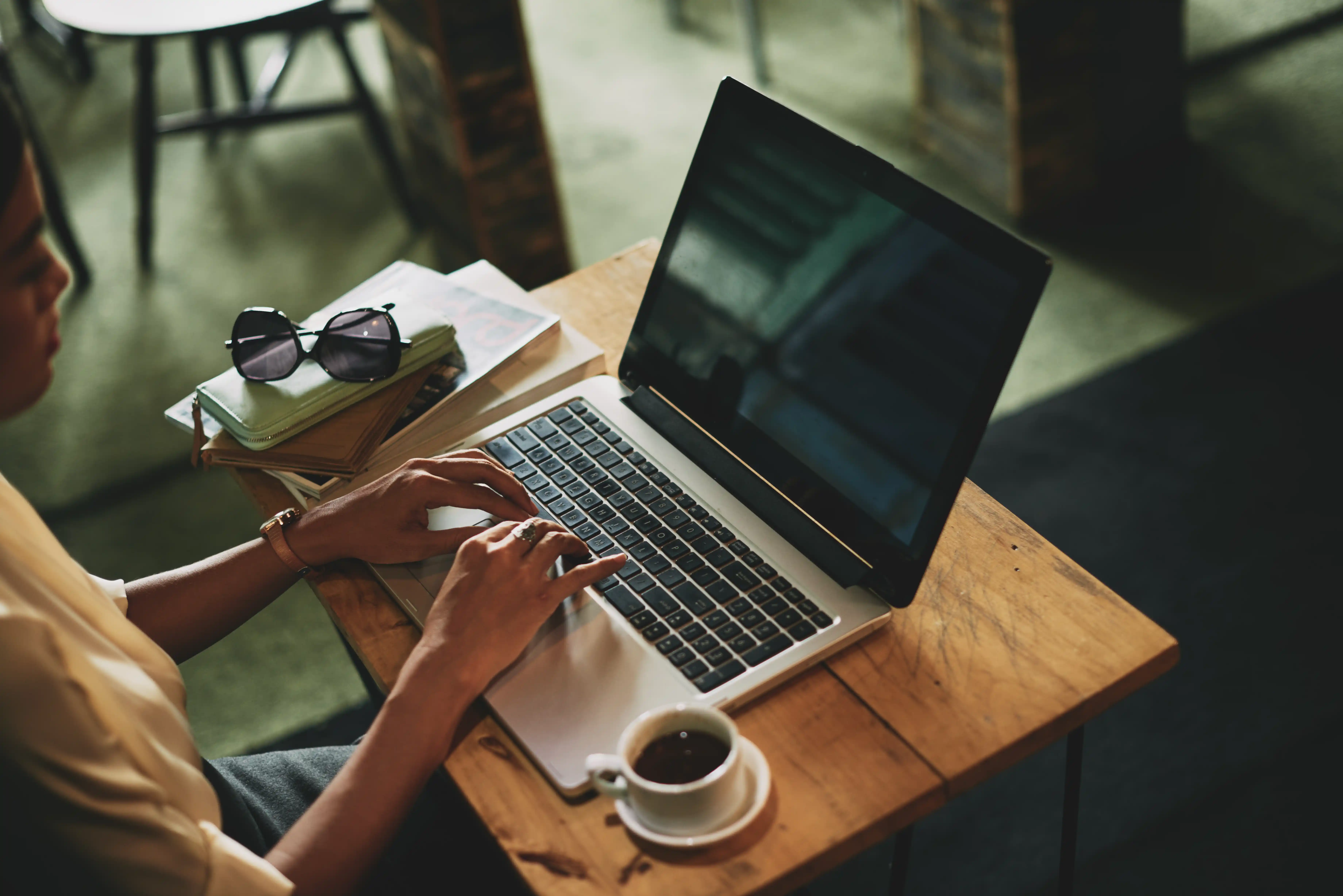 Femme asiatique assise dans un café travaillant sur un ordinateur portable