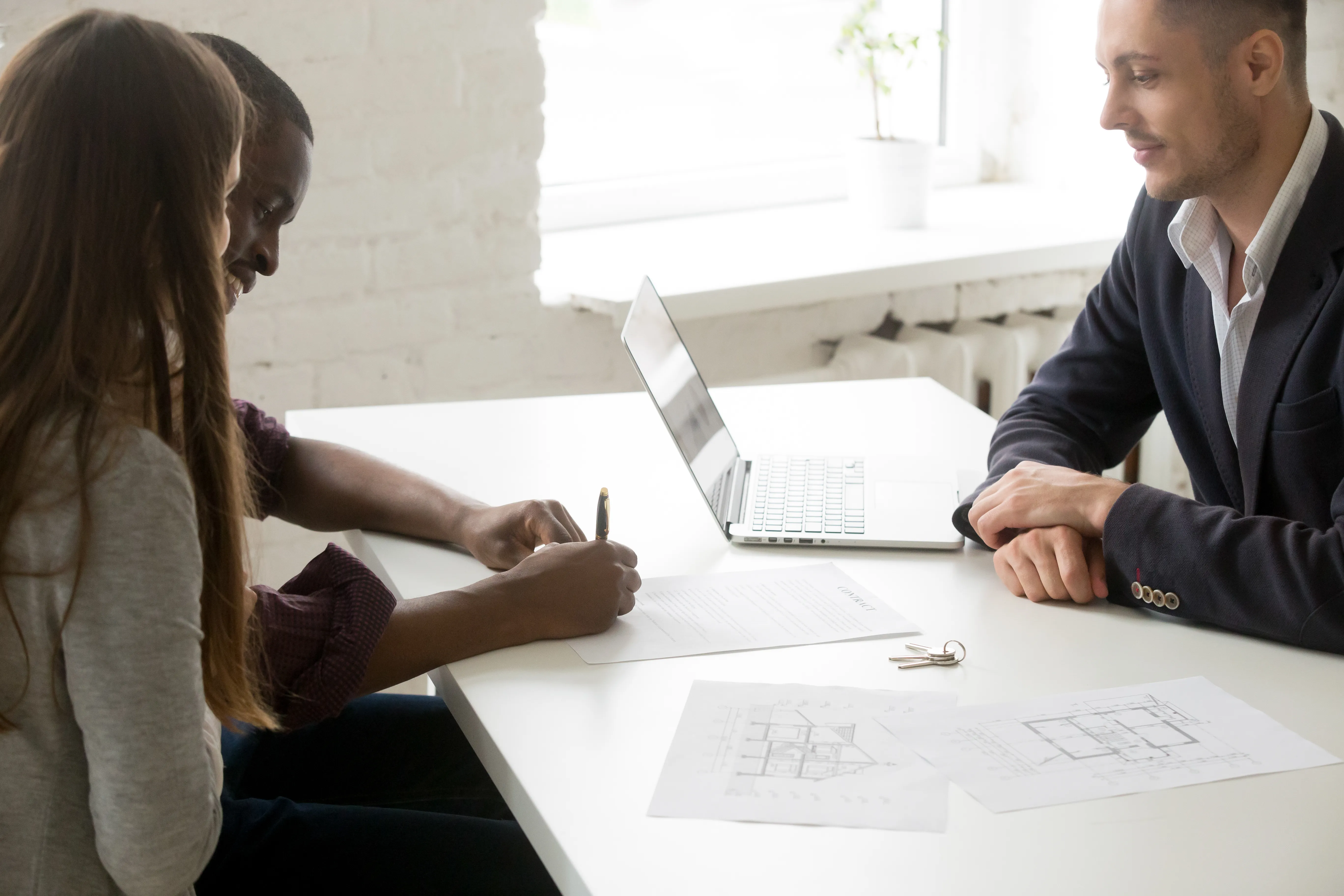 Couple signant un contrat d'investissement immobilier avec un courtier