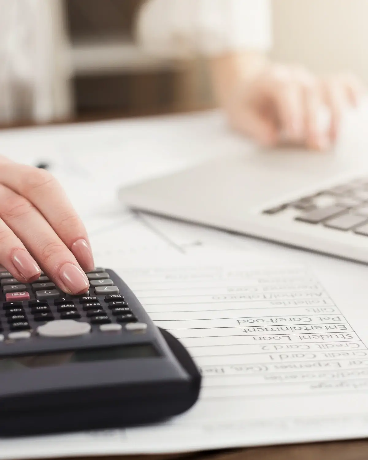 Main sur une calculatrice posée sur des documents