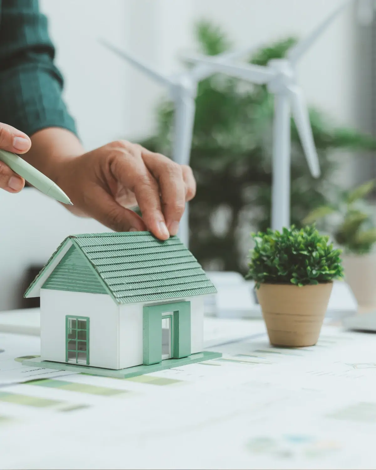 Maquette de maison et petites éoliennes sur une table de travail