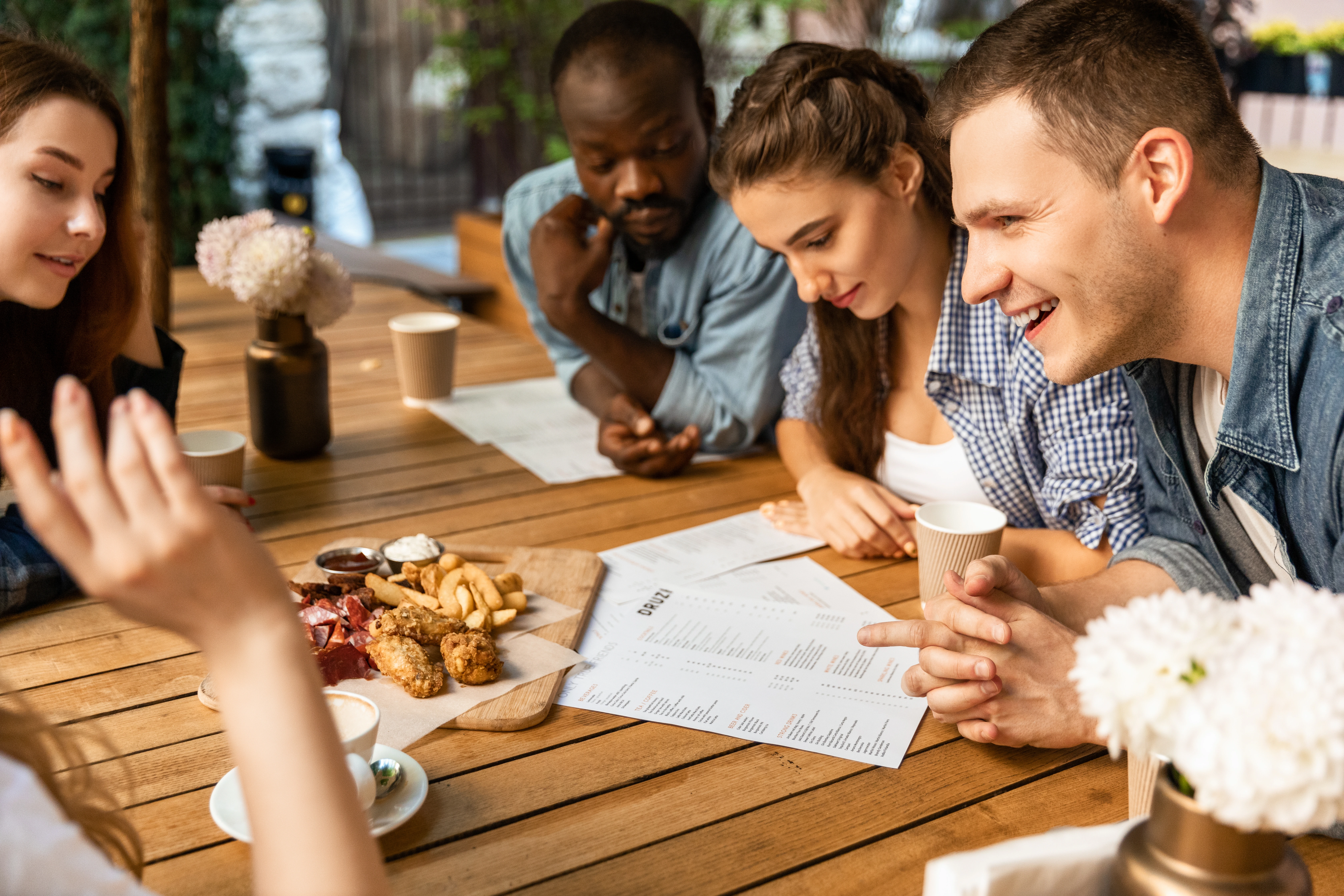 Personnes consultant un menu dans un café en plein air